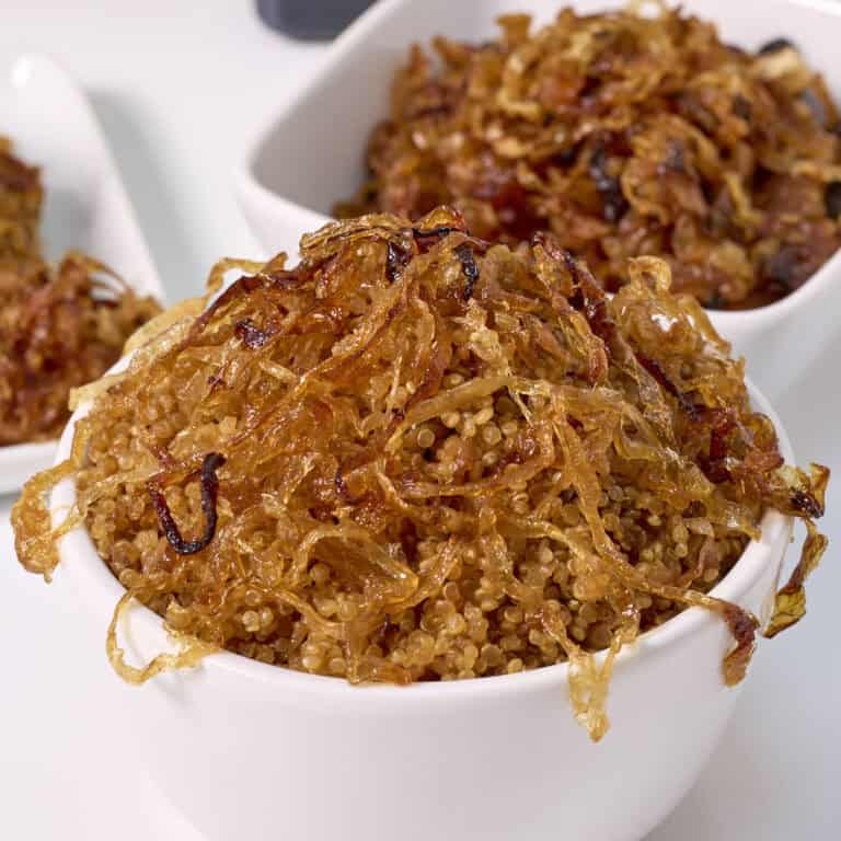 French onion quinoa in a serving bowl with extra carmelized onions in the background