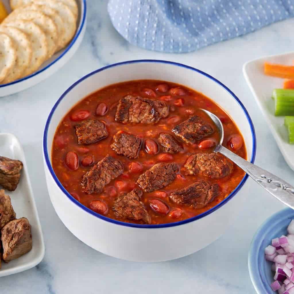 Bowl of chuckwagon chili made with lean stew meat, garnished and served as a high-protein GLP-1 recipe