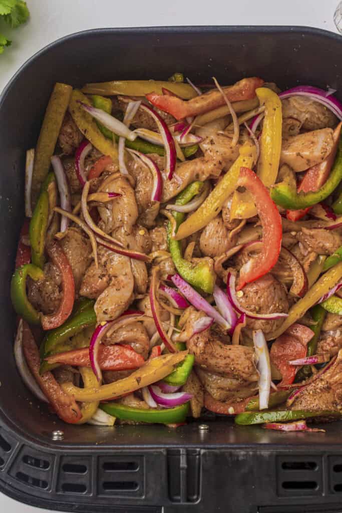The ingredients loaded into an air fryer basket