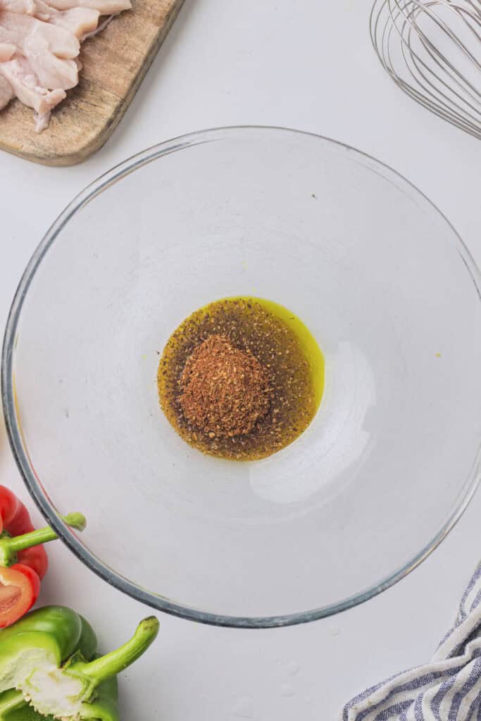 The seasoning and olive oil in the bowl to form the fajita marinade