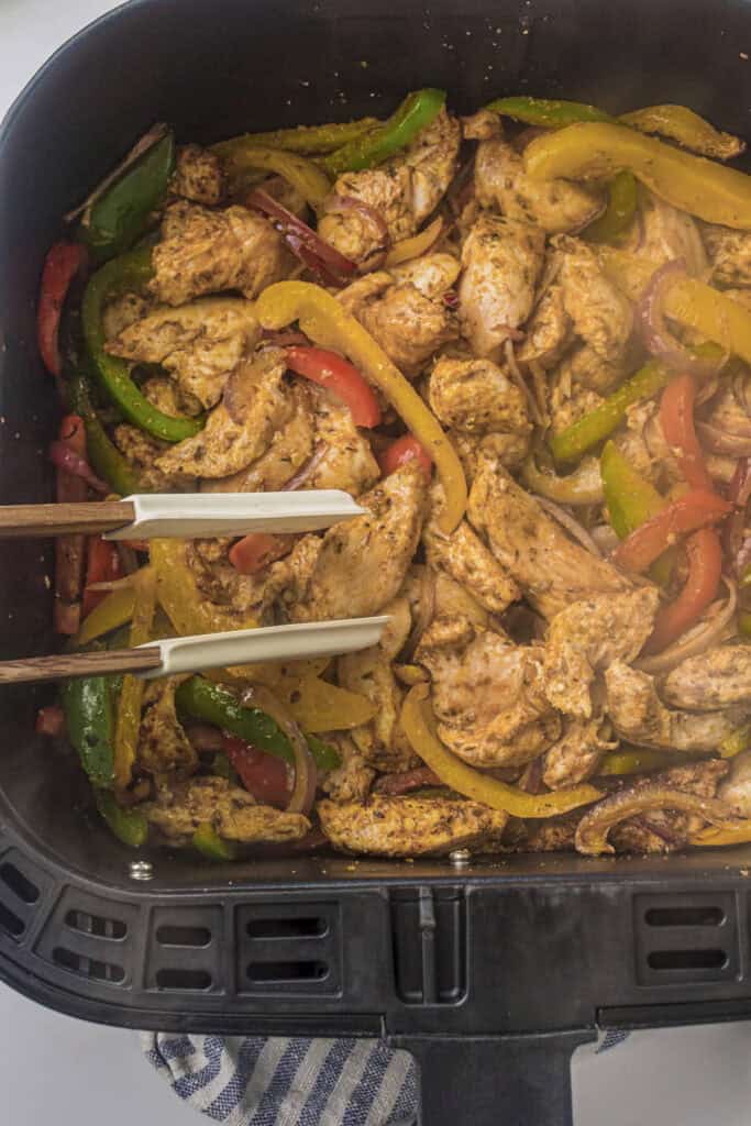 Turning the pieces to ensure even cooking in the air fryer basket