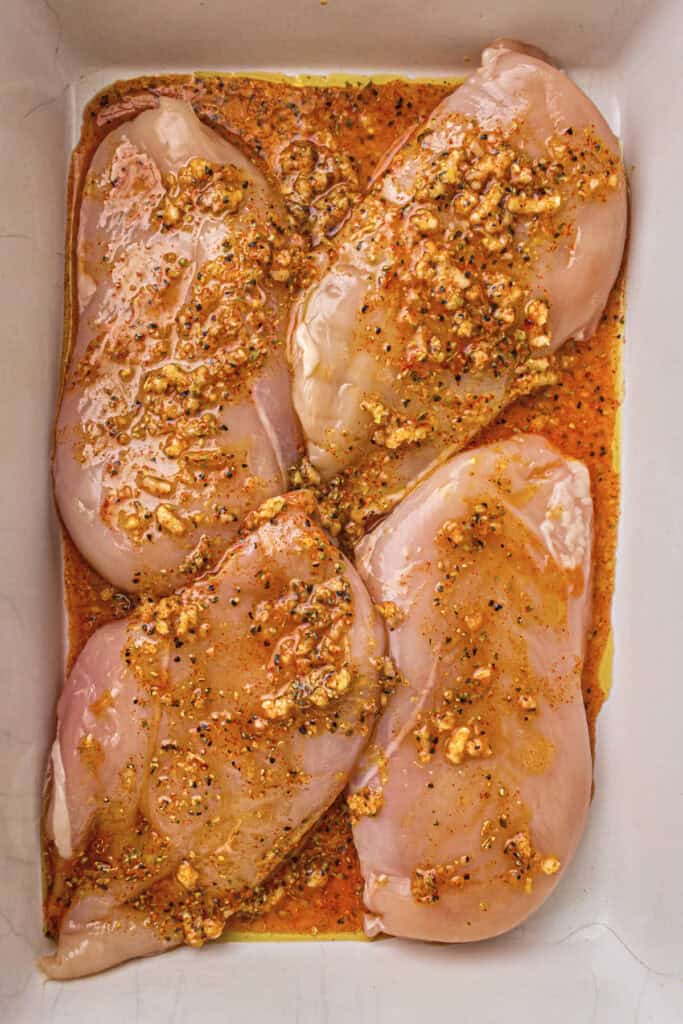 The marinated chicken breasts in the baking dish