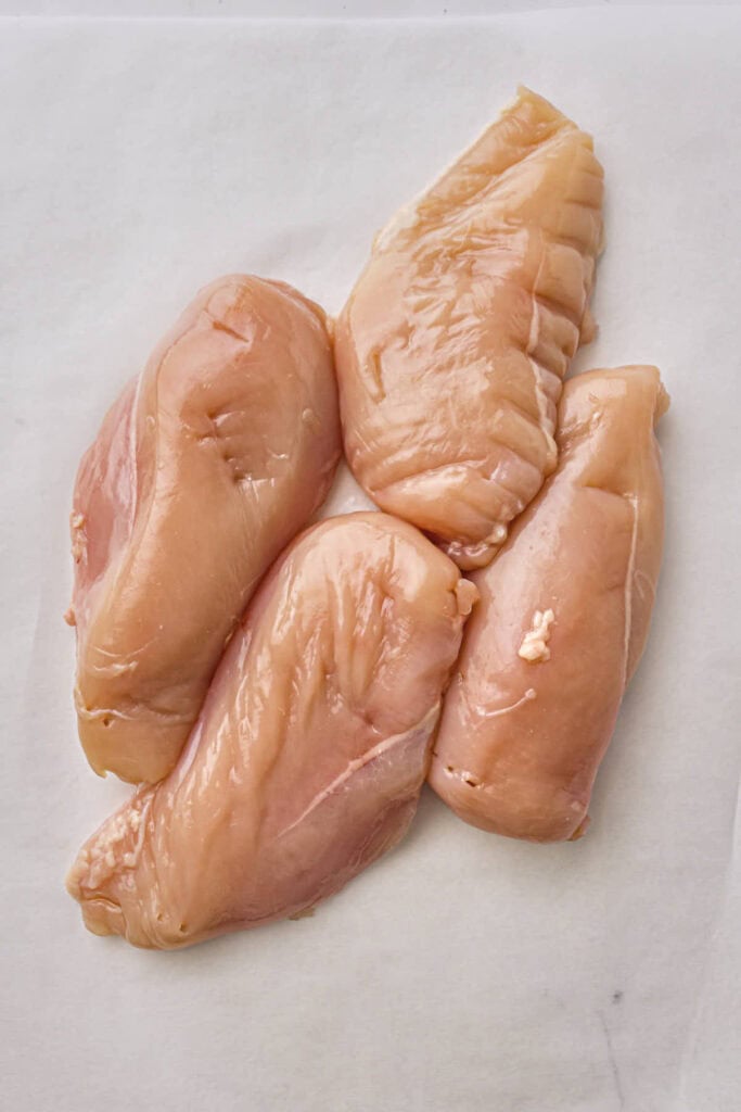 Four chicken breasts on the kitchen surface