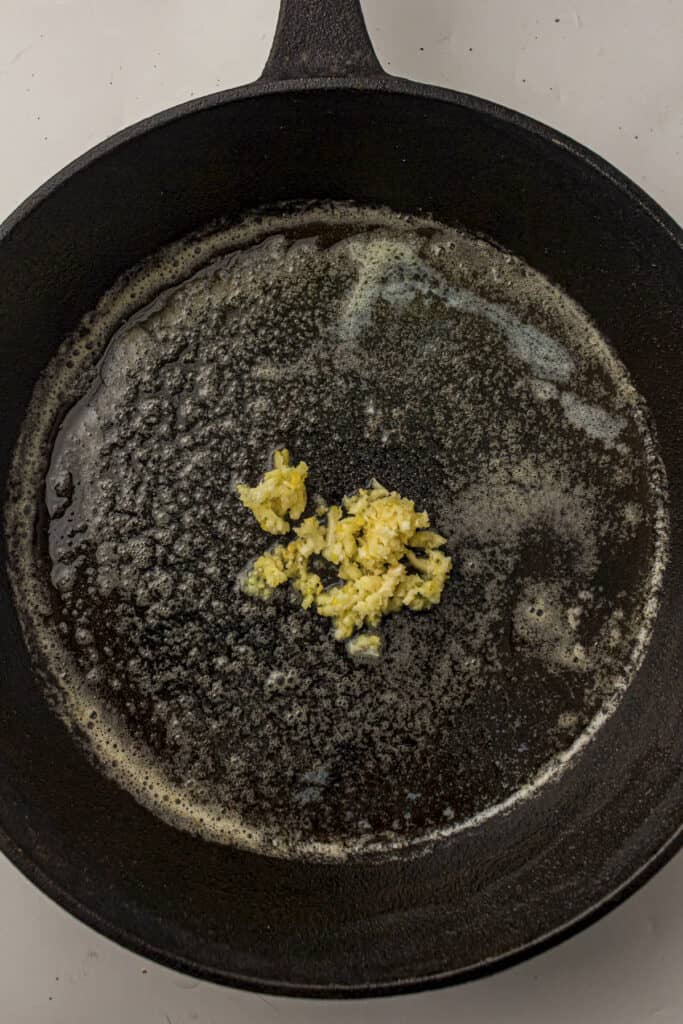 Minced garlic in the skillet with the melted butter