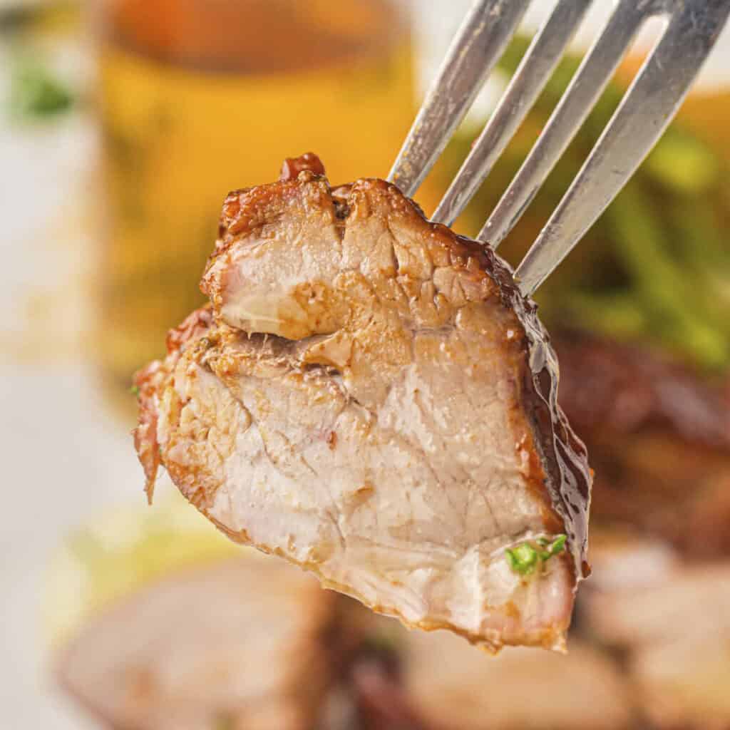 Grilled pork tenderloin from this recipe shown on a fork