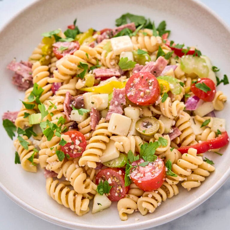 High protein pasta salad from this recipe shown on a plate garnished with some chopped parsley