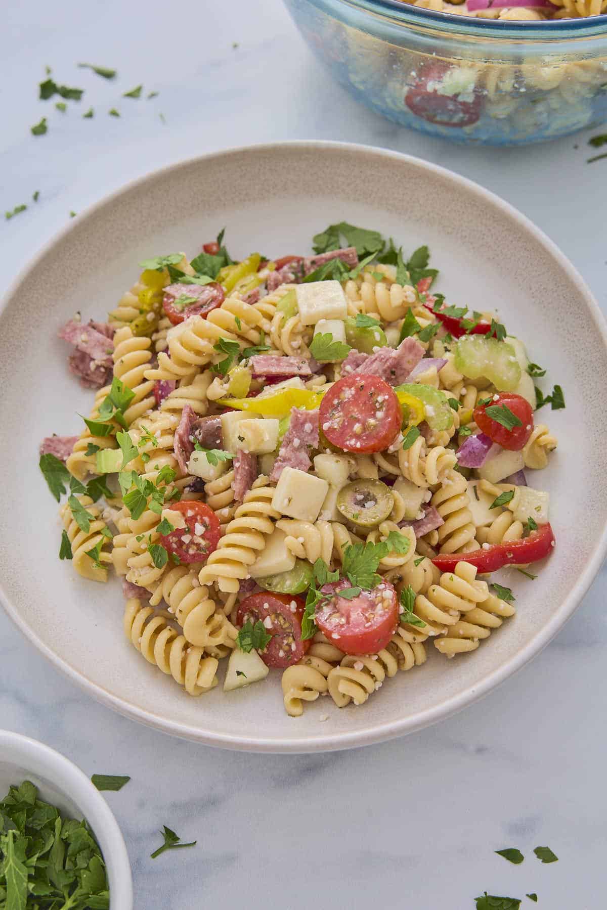 Hero shot of some of the pasta salad from this recipe served on a plate and garnished with some chopped parsley