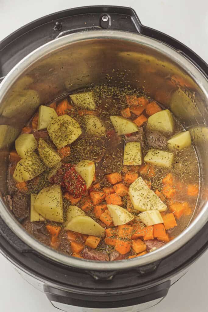 Add the veggies, tomato paste, seasoning, and liquid to the instant pot