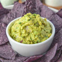 Keto guacamole from this recipe surrounded by some organic blue corn tortilla chips