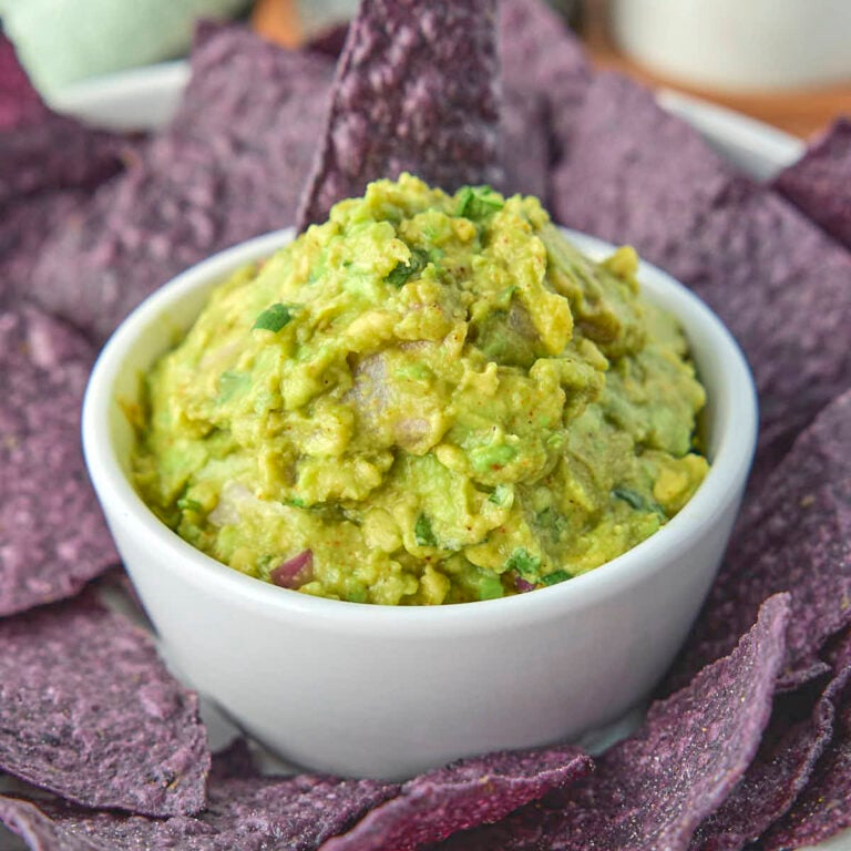 Keto guacamole from this recipe surrounded by some organic blue corn tortilla chips