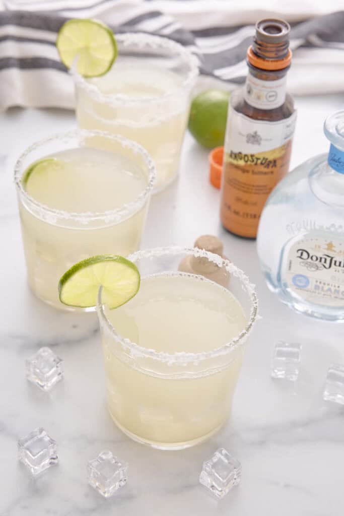 three margaritas poured into glasses with salted rims