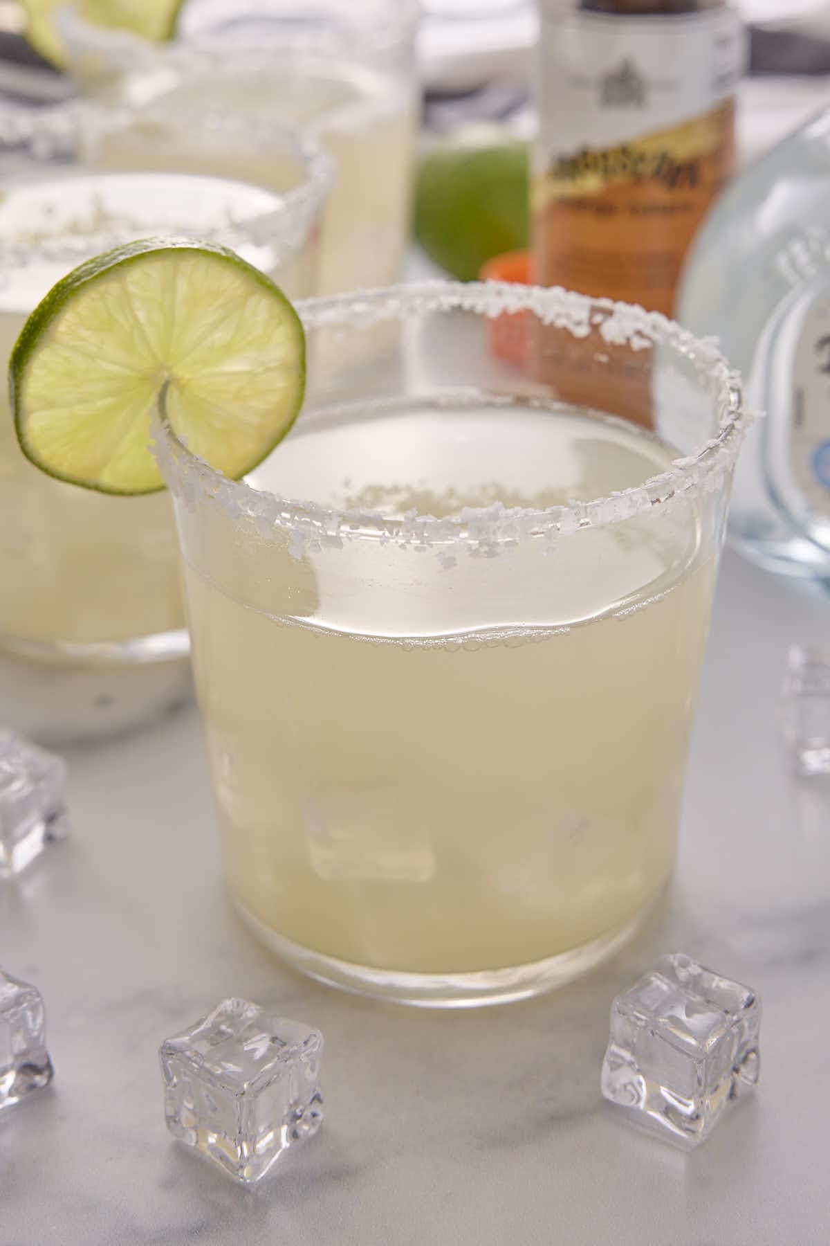 tall photo of low carb margaritas with a bottle of tequila present