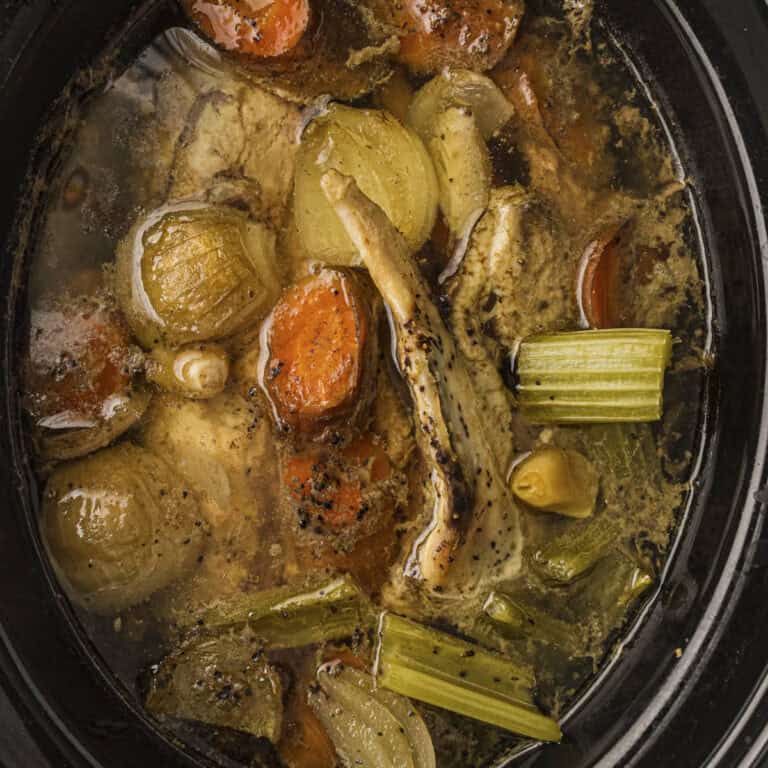 Slow cooker chicken stock featured in the slow cooker pot before straining
