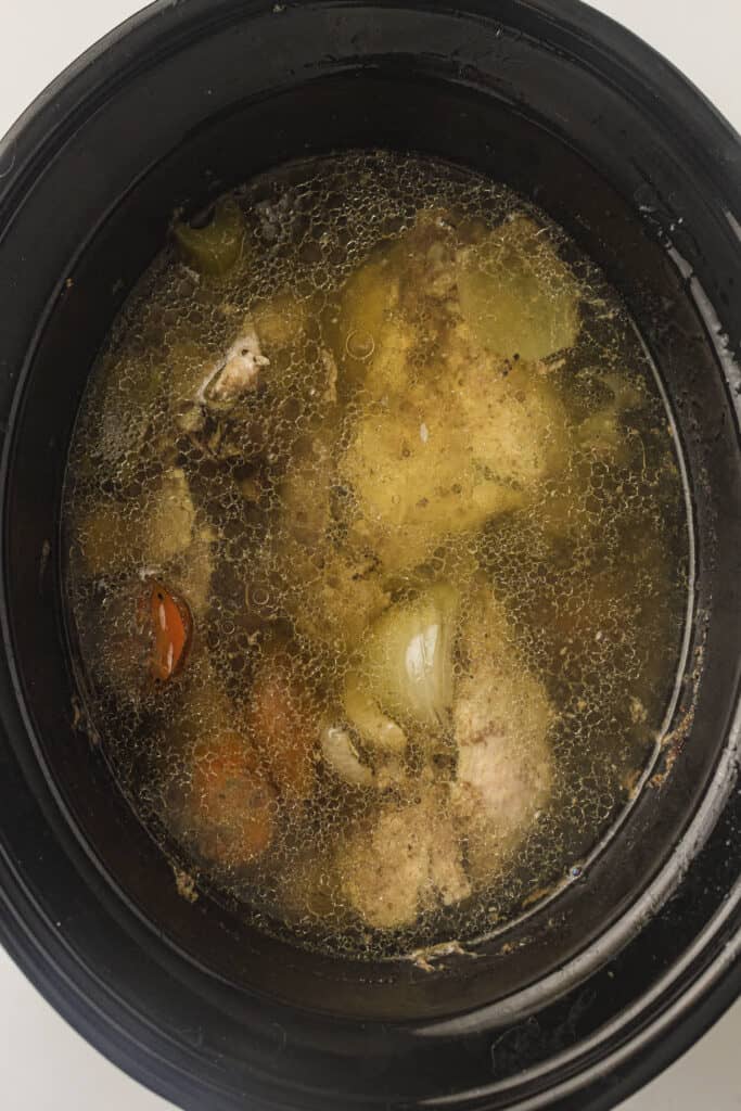 Crockpot with about half of the chicken and vegetables removed