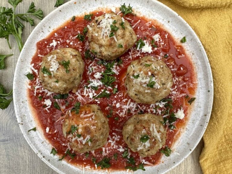 high protein turkey meatballs on a plate with sauce and cheese