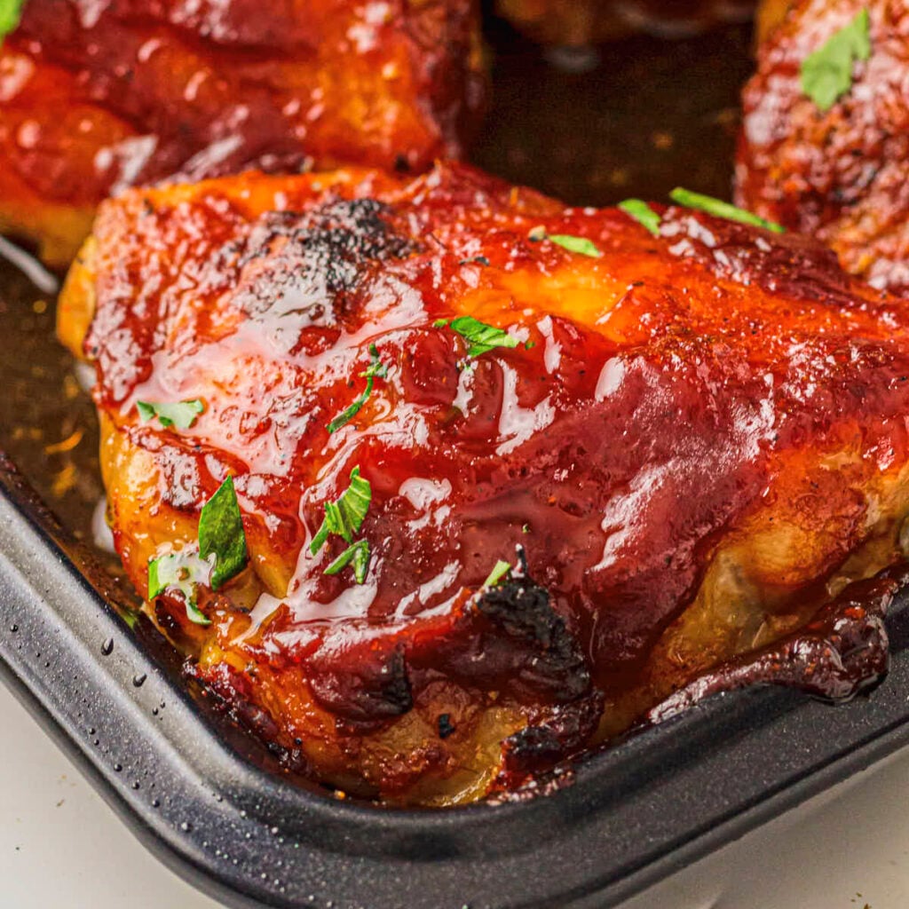 Baked BBQ chicken thighs in the sheet pan covered with a low-carb BBQ sauce