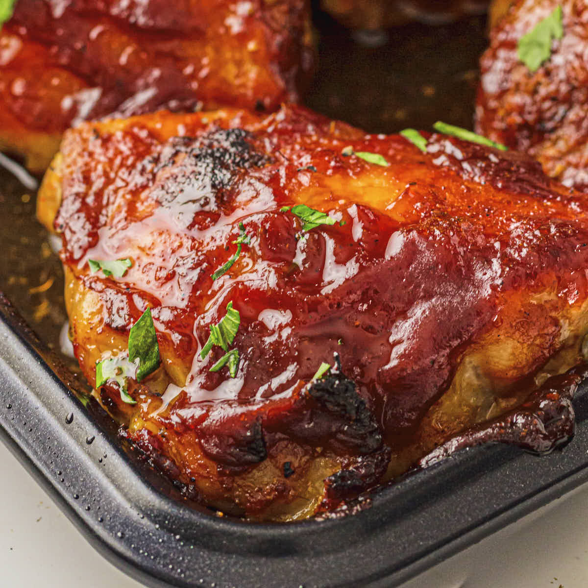 Baked BBQ chicken thighs in the sheet pan covered with a low-carb BBQ sauce