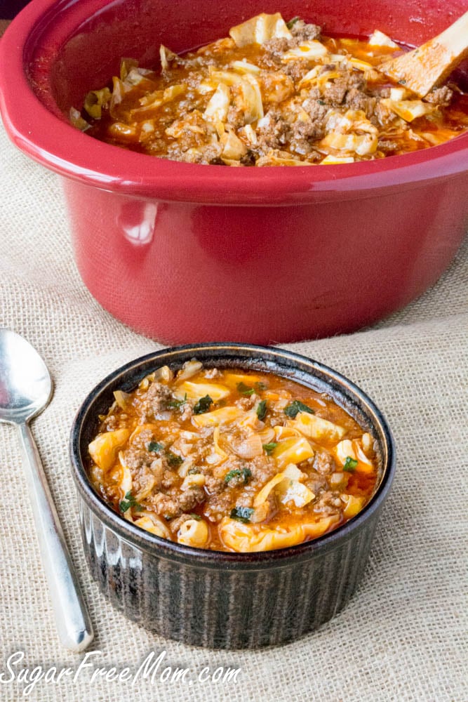 A small crock of cabbage roll soup below the crockpot full